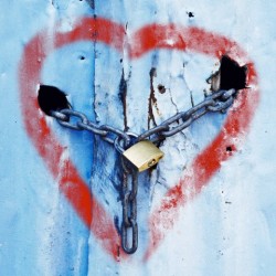Heart shape spray painted on surface of corrugated metal doors